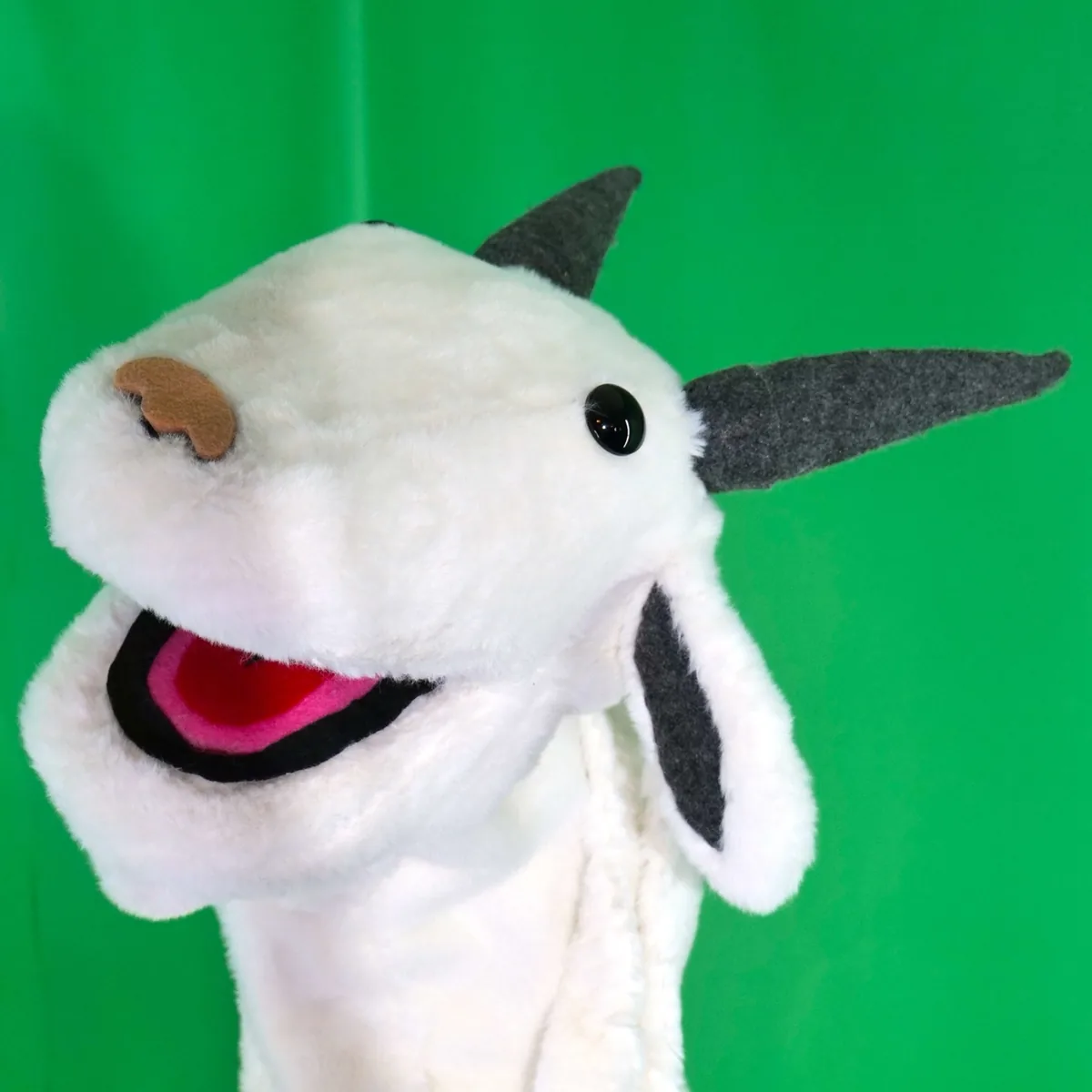 Becky the plush goat puppet grinning, close up